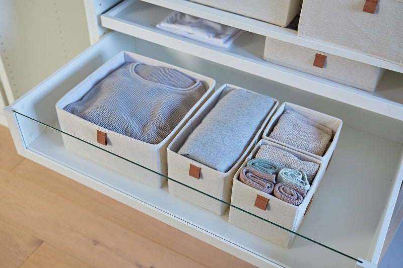 Schubladen Organizer mit ordentlich sortierter Kleidung
